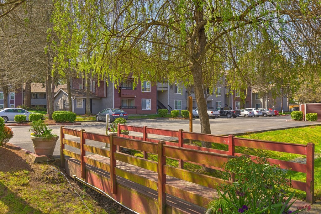 a park with a wooden fence in front of an apartment building