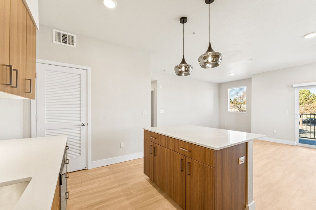 a white kitchen with wooden cabinets and a white counter top