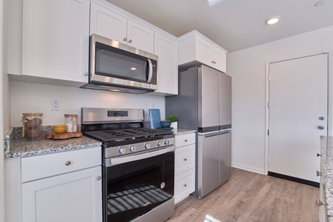 a kitchen with stainless steel appliances and white cabinets