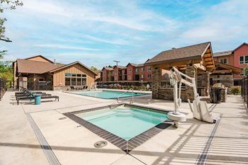 A large outdoor swimming pool with a slide and sun loungers.