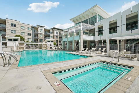 A swimming pool in front of apartment buildings.