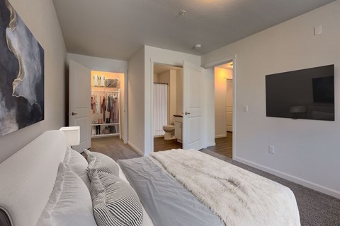 A bedroom with a large bed and a painting on the wall.