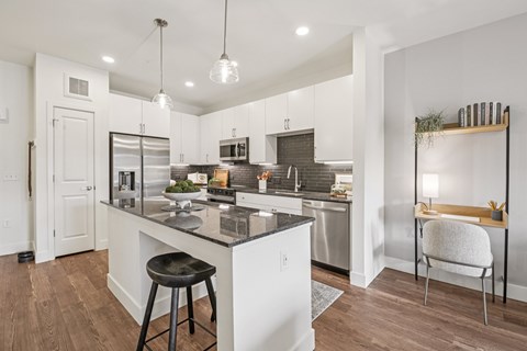 A modern kitchen with a white island and stools.