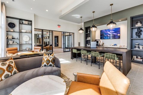 A modern living room with a grey couch and a brown leather chair.