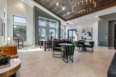 A modern dining room with a wooden ceiling and a large table surrounded by chairs.