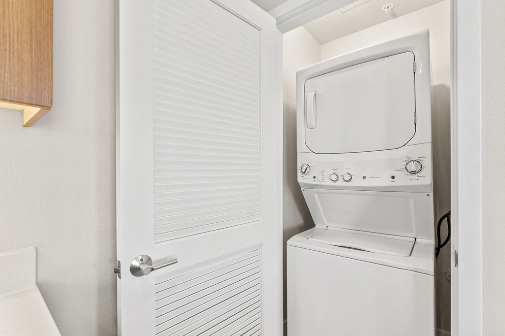 a white washer and dryer in a closet next to a white door