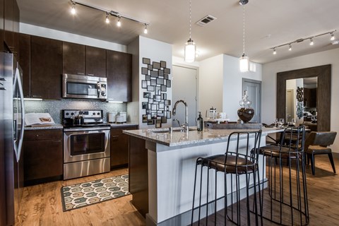 a kitchen with a bar and stools in front of a counter top