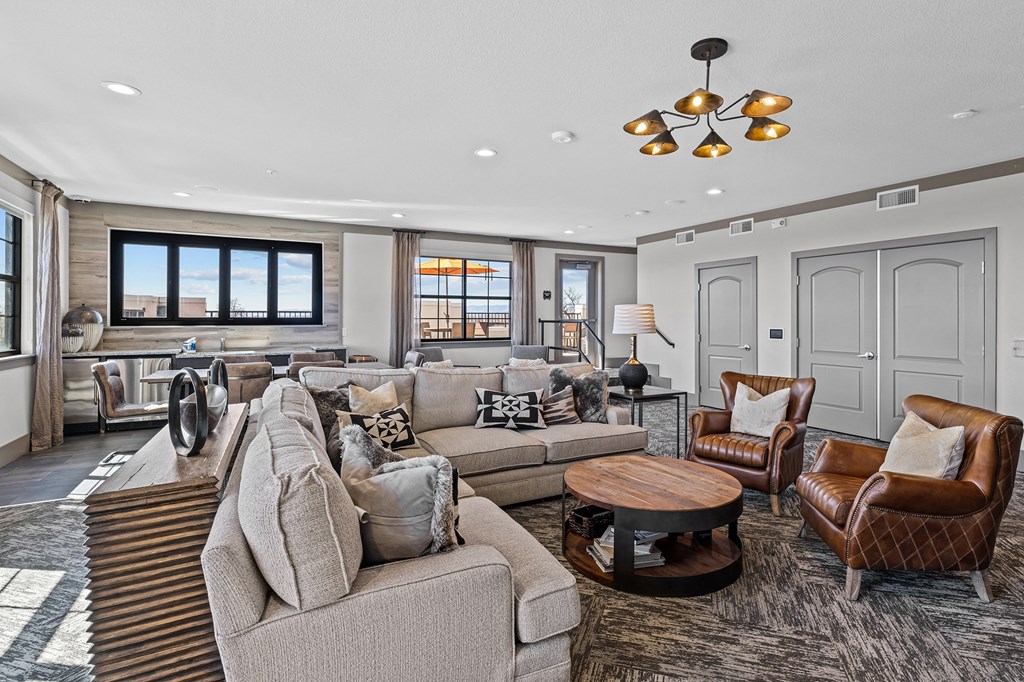 a living room with couches and chairs and a kitchen
