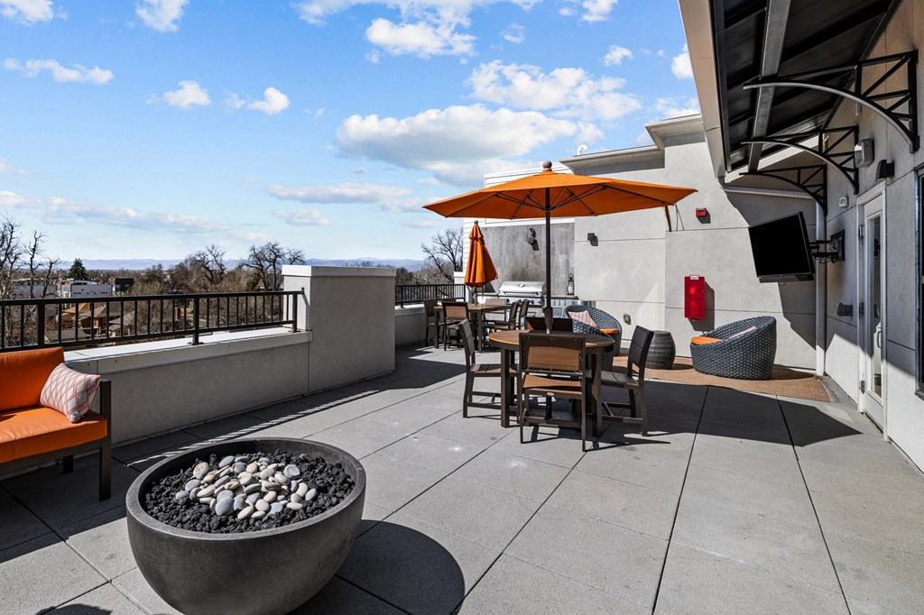 a patio with tables and chairs and a fire pit