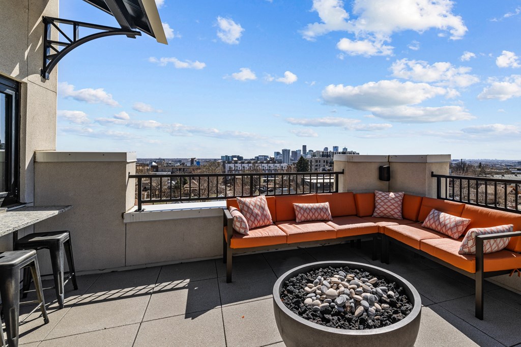 a rooftop patio with a couch and a fire pit
