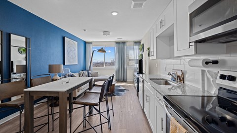 a kitchen and living room with blue walls and white cabinets
