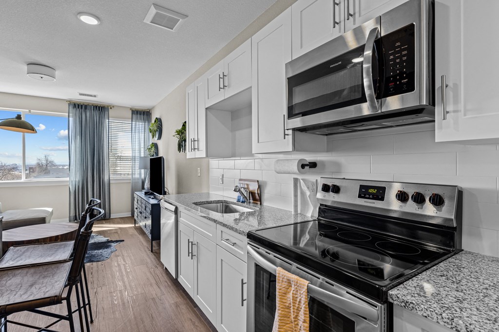 an updated kitchen with white cabinets and stainless steel appliances