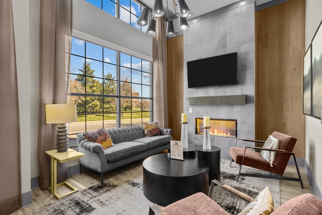 a living room with couches and a fireplace and a large window