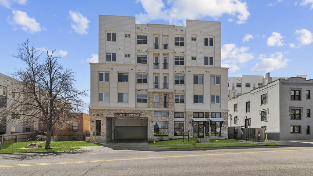 an apartment building with a garage on a city street