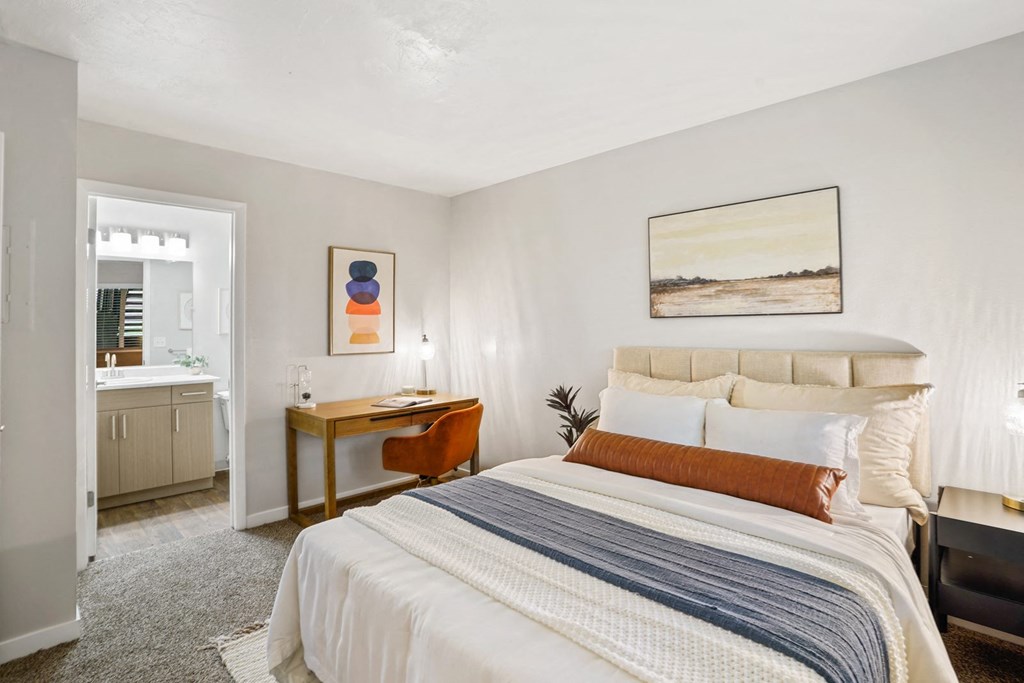 The Grove Apartments bedroom with large bed and two nightstands and desk with bathroom