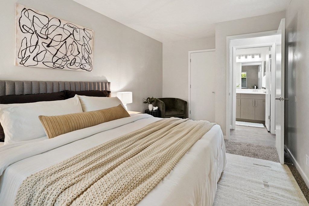 The Grove Apartments bedroom with large bed and nightstands and bathroom