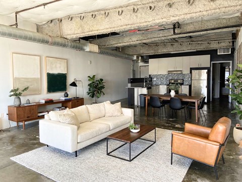 A living room with a white couch and a brown leather chair.