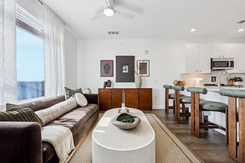 A modern living room with a brown couch and a white coffee table.