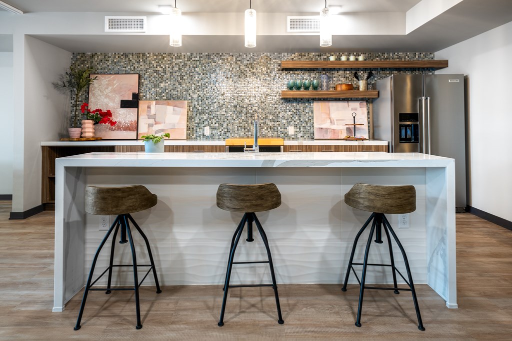 A kitchen with a bar area featuring two stools.