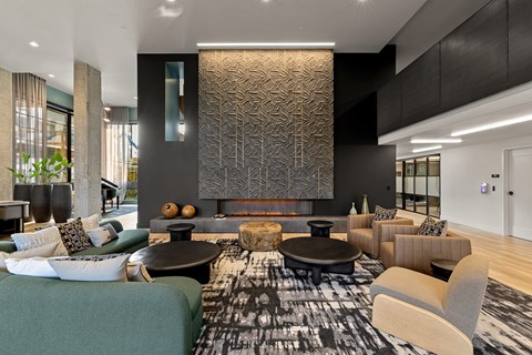 A modern living room with a black and white patterned rug and a fireplace.
