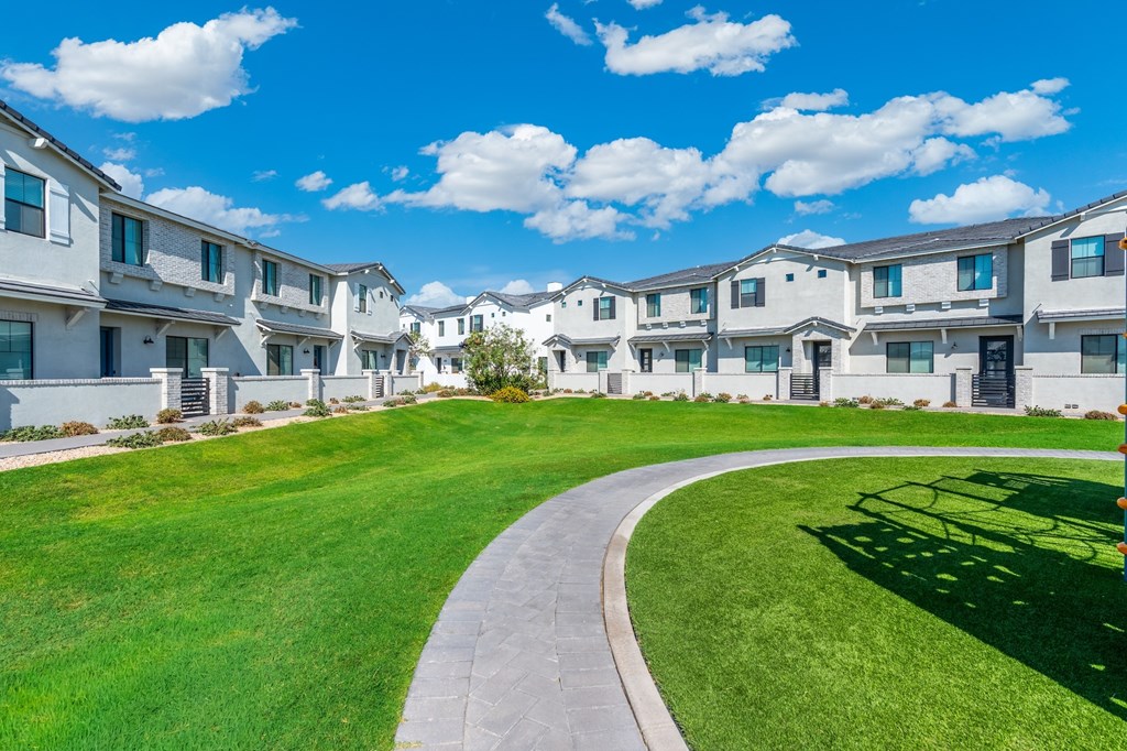 A row of white houses with a curved walkway in the foreground.