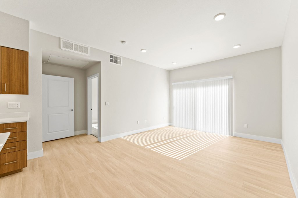 an empty living room with white walls and wood flooring