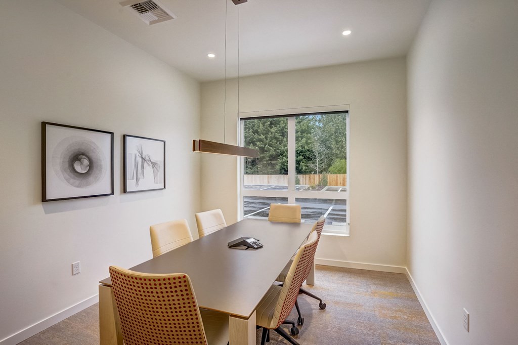 a conference room with a table and chairs and a large window