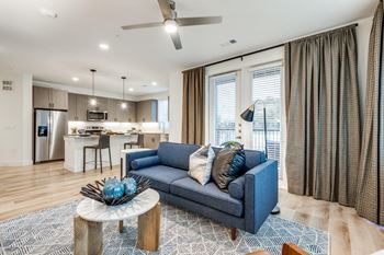 A blue couch with a bowl of blue balls on a coffee table in a living room.