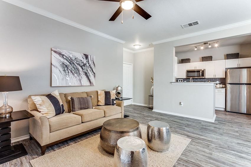 a living area with a couch coffee table and a kitchen in the background