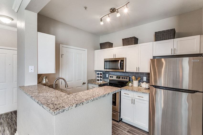 a kitchen with white cabinets and a granite counter top