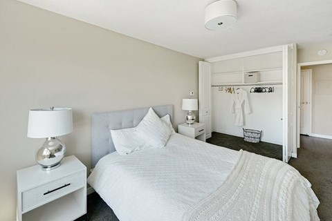 Bedroom with neutral colored walls and lots of natural light at  735 St. Clair Apartments in Portland, Oregon