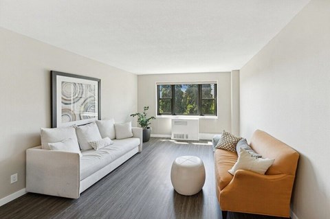 A living room with a white couch and a brown chair.
