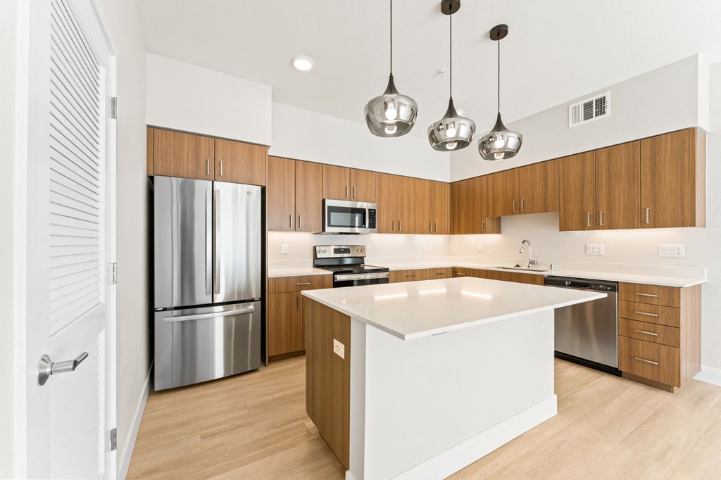 a white kitchen with stainless steel appliances and wooden cabinets