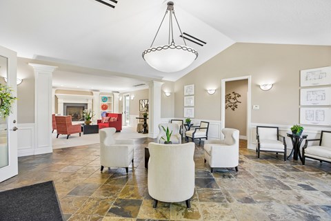 A large, well-lit room with a variety of seating options and a chandelier hanging from the ceiling.