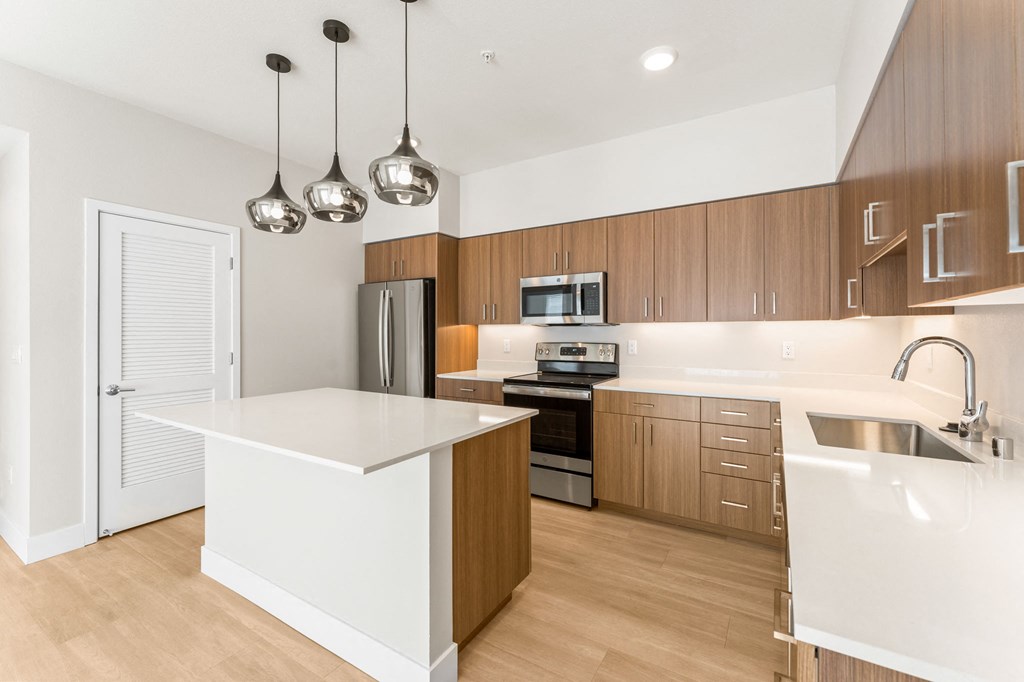 a white kitchen with wooden cabinets and stainless steel appliances