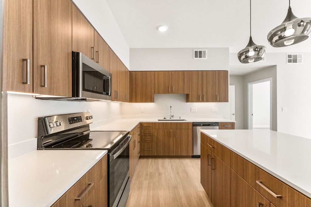 a large kitchen with wooden cabinets and white counter tops