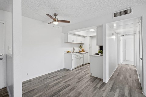 A kitchen with white cabinets and a ceiling fan.