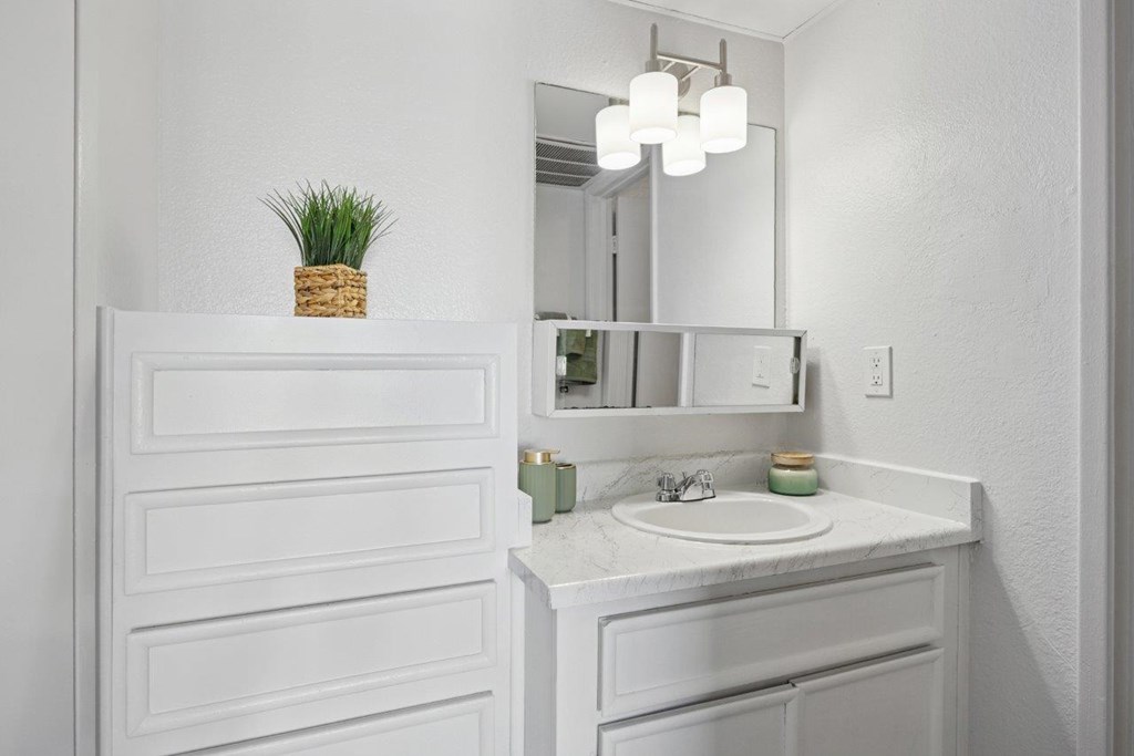 Madera at Metro  A white bathroom with a sink and mirror.