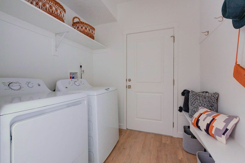 a small laundry room with a washer and dryer and a white door