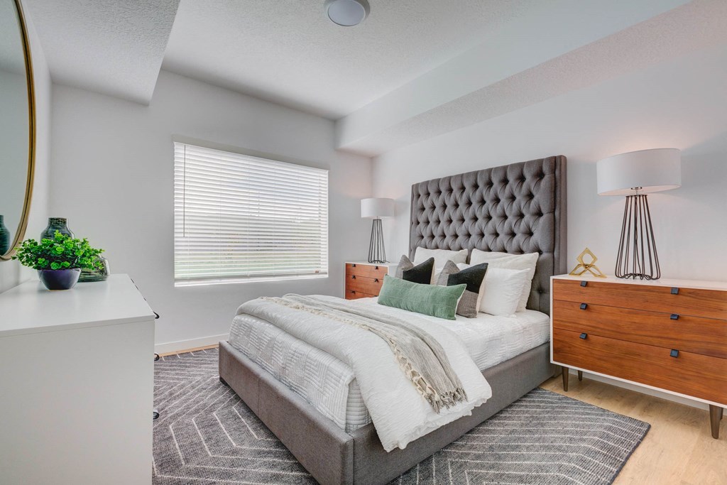 a bedroom with a bed and a dresser and a window