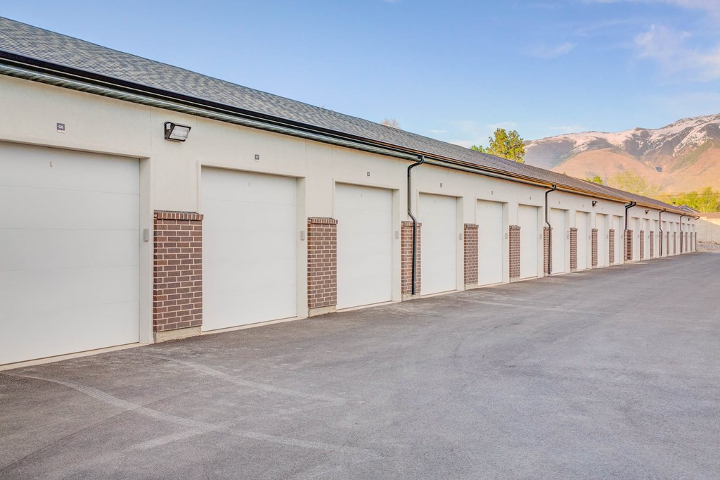 a row of garage doors on a building with mountains in the background