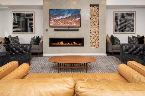 A living room with a fireplace and a painting on the wall.