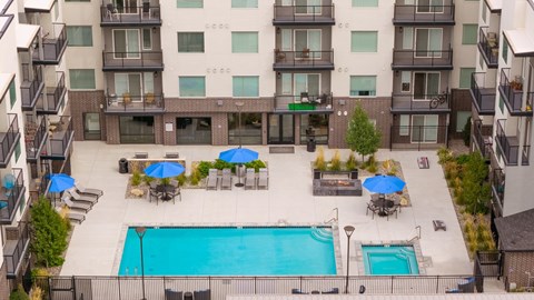 An aerial view of a pool surrounded by umbrellas and chairs.