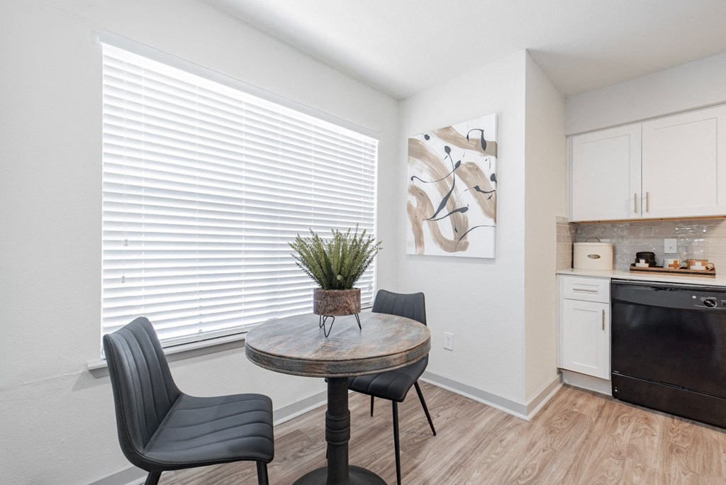 a dining room with a table and chairs and a kitchen