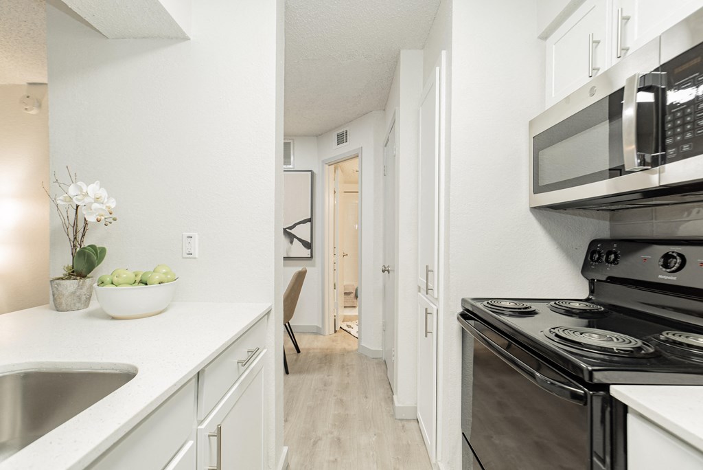 a renovated kitchen with white cabinets and stainless steel appliances