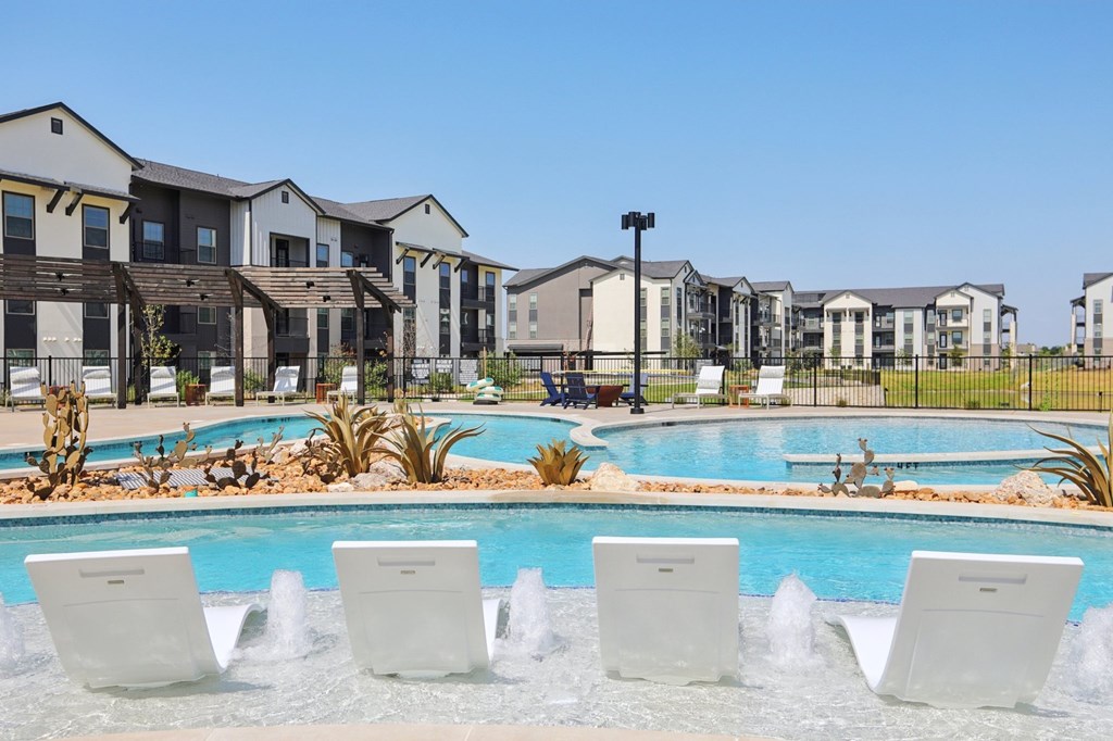 A row of houses with a pool in front.