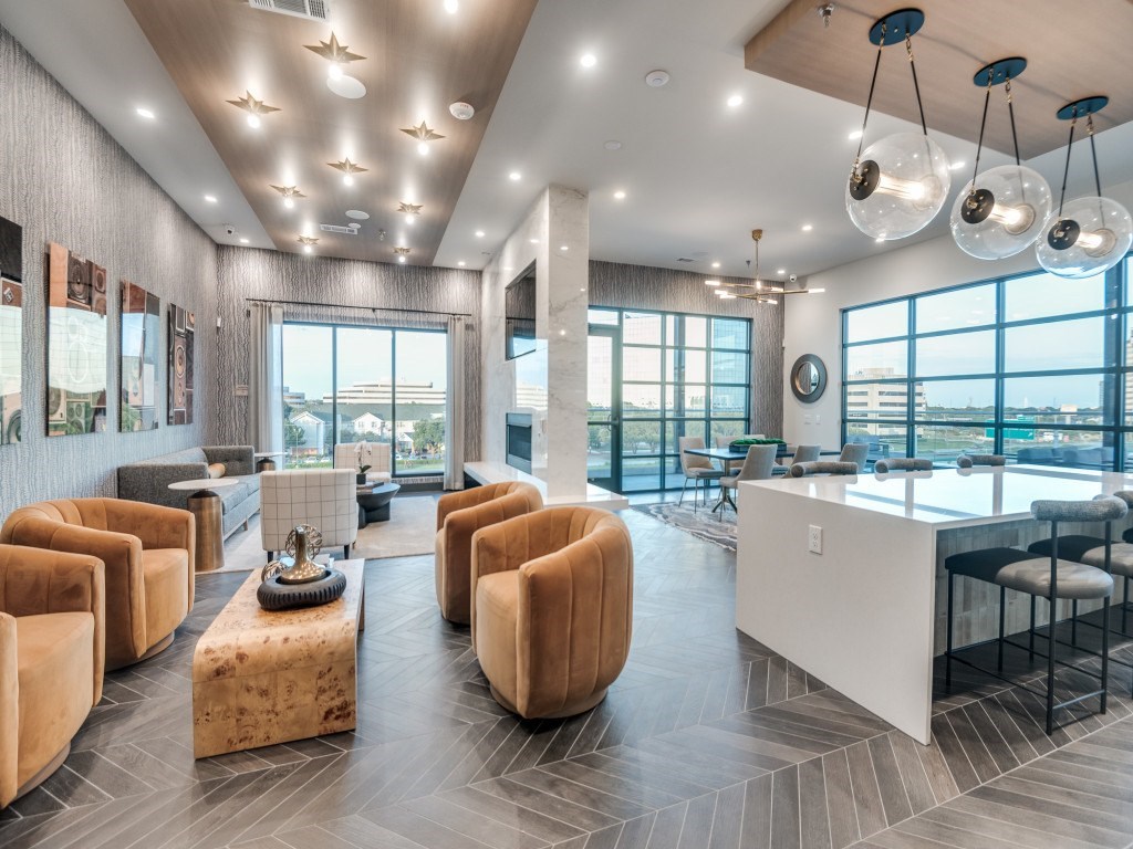 A modern living room with a large window and a kitchen area.