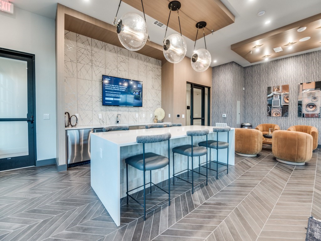 A modern bar area with a long counter and stools.