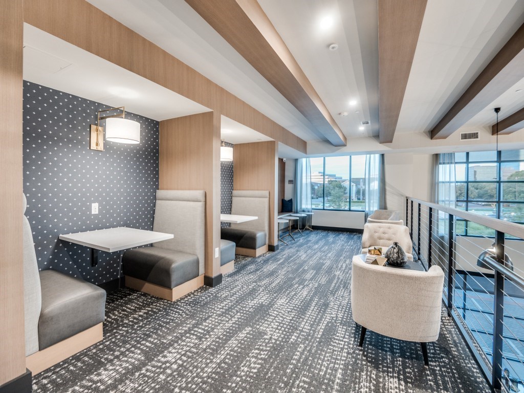 A long hallway with a carpeted floor and a bench on the side.