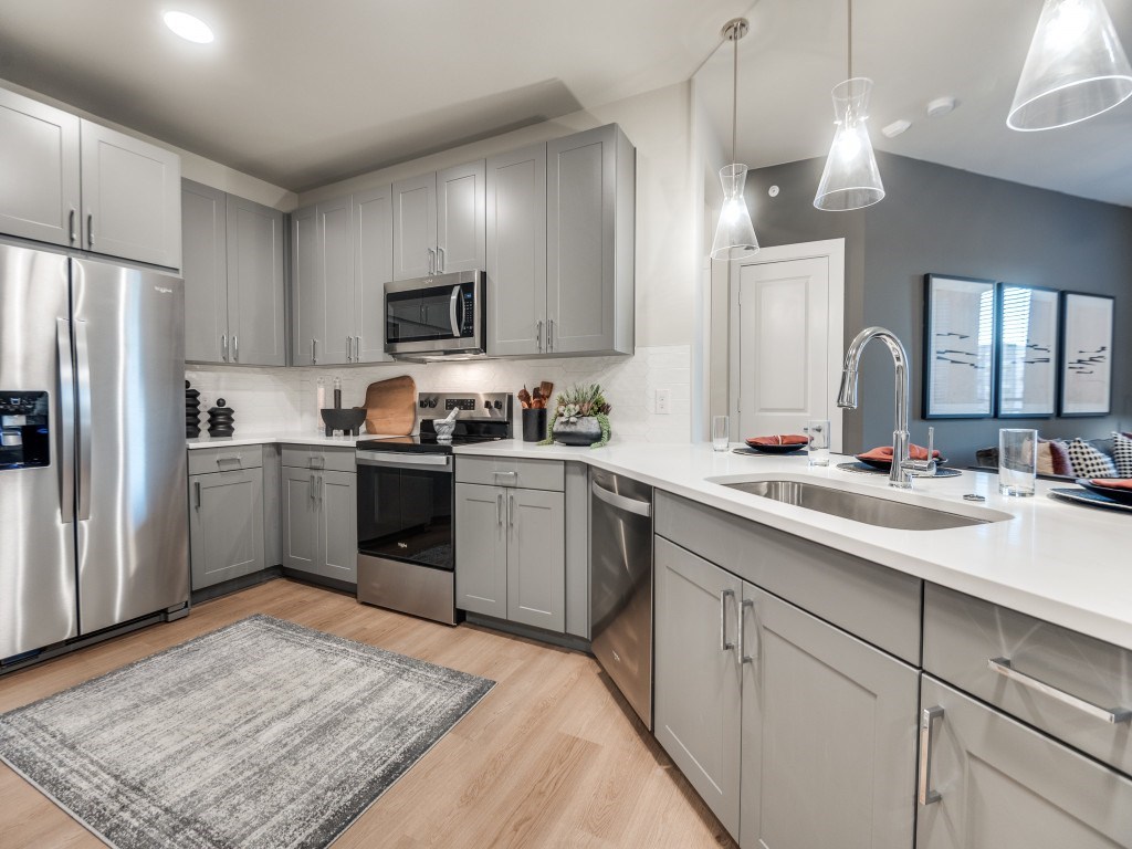 A modern kitchen with stainless steel appliances and white countertops.